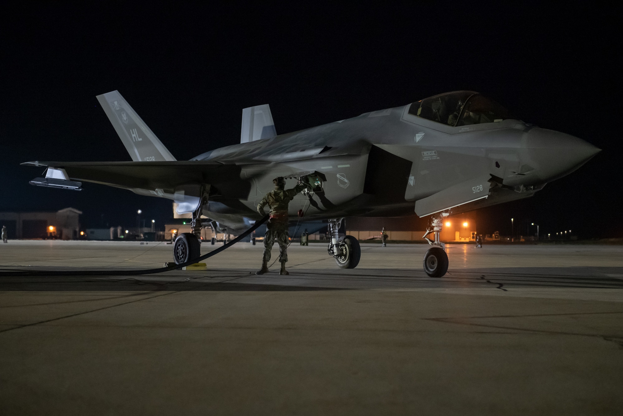 An Airman monitors an F-35A Lightning II during a hot pit refuel