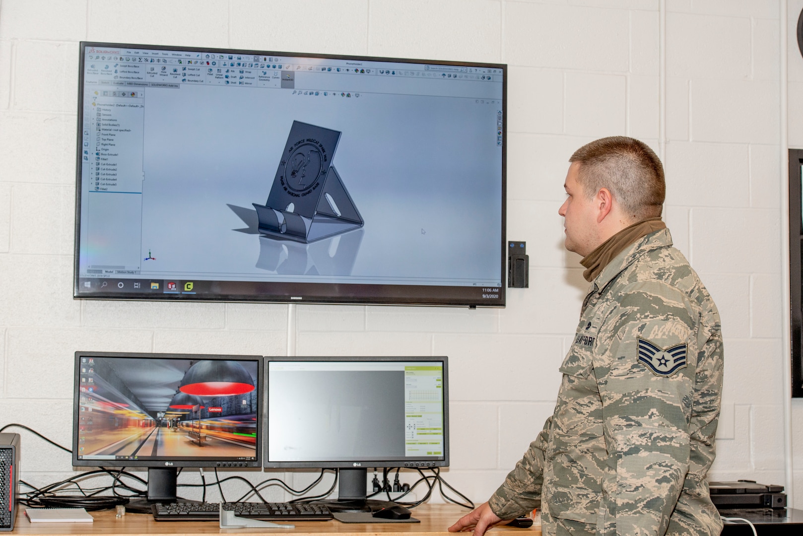 Staff Sgt. John Woodward, a metals technician with the 157th Maintenance Group, reviews a 3D printable mobile phone holder prototype at Pease Air National Guard Base, N.H., Sept. 3, 2020. The unit's 3D printer allows technicians to create prototypes, plastic tools and molds for crafting multifaceted equipment. (U.S. Air National Guard photo by Staff Sgt. Victoria Nelson)