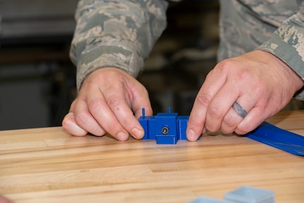 Staff Sgt. John Woodward, a metals technician with the 157th Maintenance Group, pieces together a 3D prototype designed to remove drain masts from the KC-46A without damaging the skin of the aircraft at Pease Air National Guard Base, N.H., Sept. 3, 2020. The printer allows technicians to create prototypes, plastic tools and molds for crafting multifaceted equipment. (U.S. Air National Guard photo by Staff Sgt. Victoria Nelson)