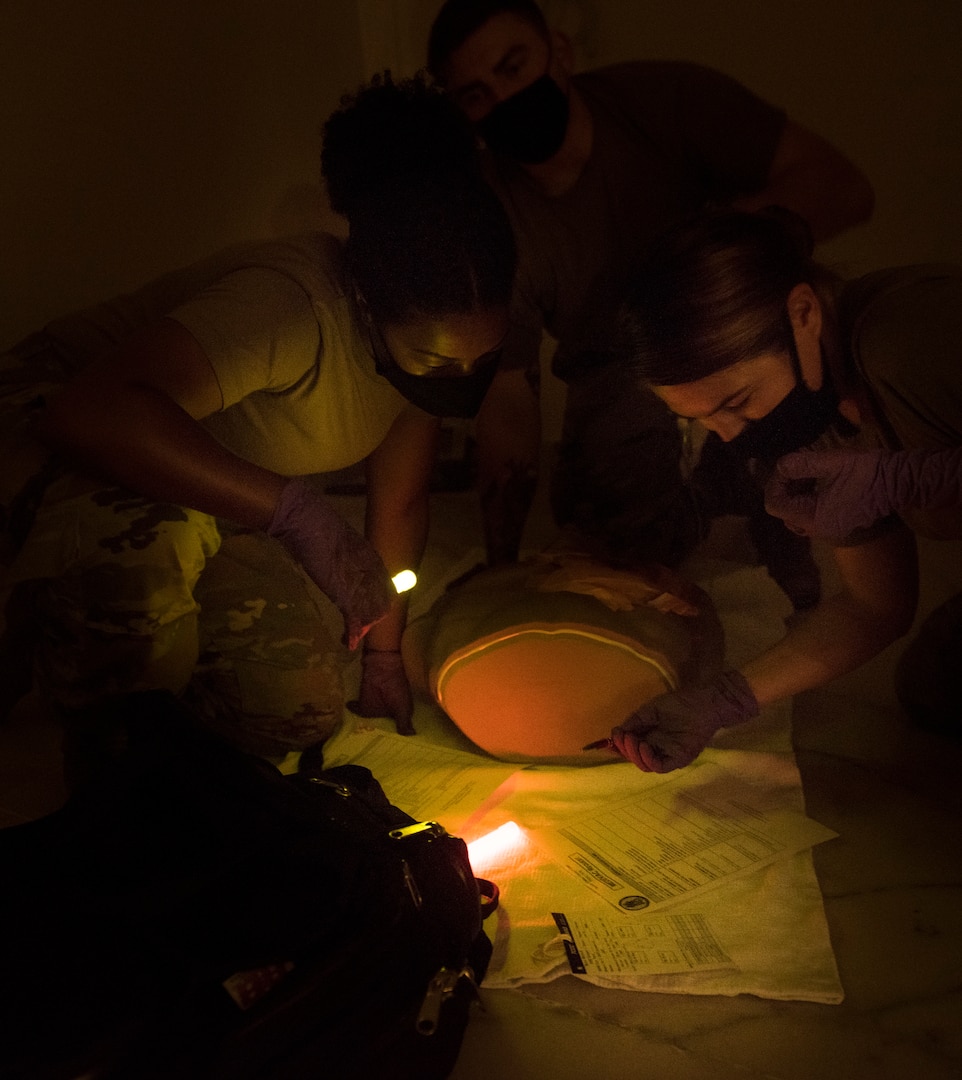 2 medical personnel using glow lights to write on paper