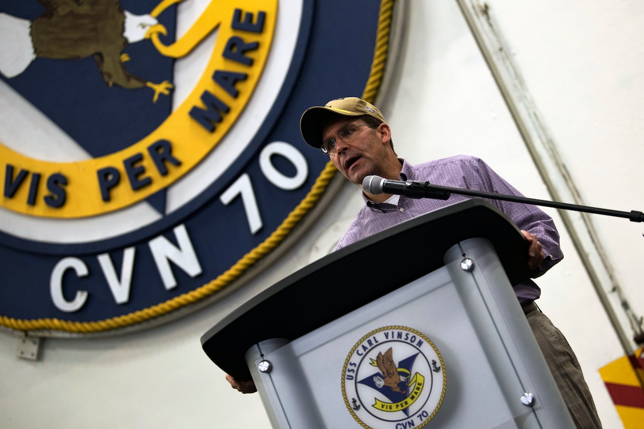 Defense Secretary Dr. Mark T. Esper speaks from behind a dias.