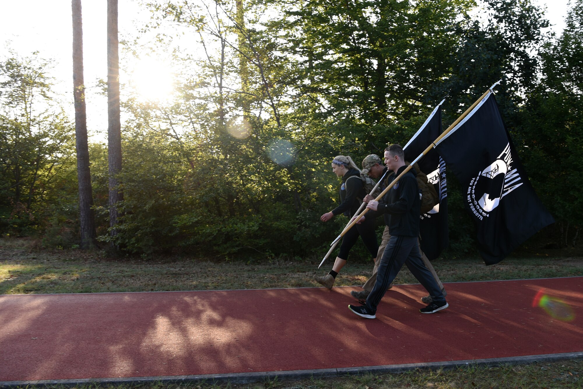 U.S. Air Force Ravens, assigned to the 86th Security Forces Squadron, walk laps around the base track while carrying POW/MIA flags at Ramstein Air Base, Germany, Sept. 18, 2020.