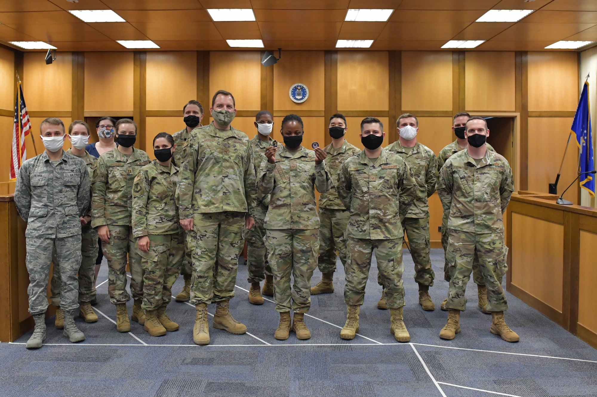 A group of Airmen standing in a courtroom.