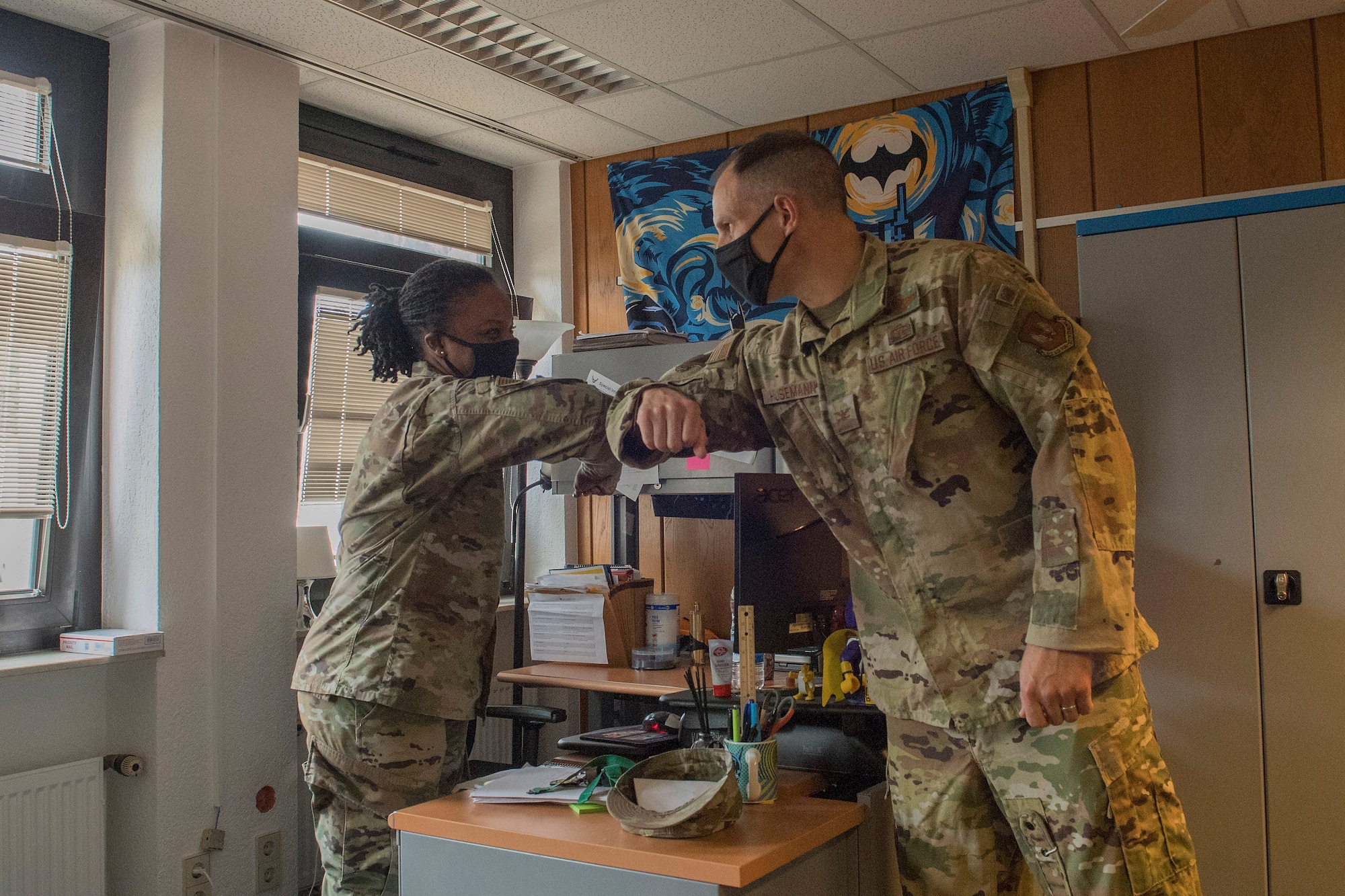 An Airman bumps elbows with another Airman.