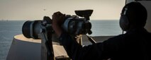 200918-N-ZR324-1014 STRAIT OF HORMUZ (Sept. 18, 2020) Seaman Antwon Brown monitors the horizon for surface and air contacts as the forward lookout aboard the aircraft carrier USS Nimitz (CVN 68) during a Strait of Hormuz transit, Sept. 18. The Nimitz Carrier Strike Group is deployed to the U.S. 5th Fleet area of operations in support of naval operations to ensure maritime stability and security in the Central Region, connecting the Mediterranean and the Pacific through the western Indian Ocean and three strategic choke points. With Nimitz as the flagship, deployed strike group assets include staffs, ships and aircraft of Carrier Strike Group 11, Destroyer Squadron 9, USS Princeton (CG 59) and Carrier Air Wing 17.  (U.S. Navy photo by Mass Communication Specialist 3rd Class Jose Madrigal)