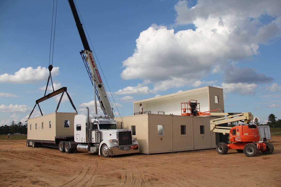 A Modular Anti-Ballistic, Blast and Forced Entry Resistant Shelter, or MABFERS, unit is lifted from a transport truck to be craned into position on the two-story structure. The U.S. Army Engineer Research and Development Center designed MABFERS to serve as personnel protection in high-threat locations abroad.