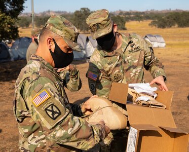Command Sgt. Maj. Phil Barretto, U.S. Army North Command Sergeant Major, (left) inspects the fire resistant boots issued to soldiers.