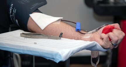 Sgt. 1st Class Timothy French from the Caisson Platoon Headquarters Support Company, Headquarters and Headquarters Battalion, U.S. Army North, grips a red ball while donating blood during a blood drive held at the Joint Base San Antonio-Fort Sam Houston Military & Family Readiness Center Sept. 16.