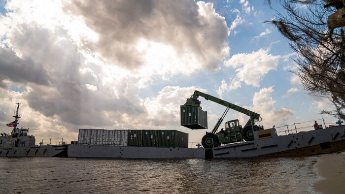 U.S. Marines use the Kalmar Rough Terrain Container Handler to offload cargo from lighterage that was transported by U.S. Sailors from USNS 1st Lt Baldomero Lopez (T-AK 3010) to Green Beach on Marine Corps Support Facility Blount Island, Feb. 12.