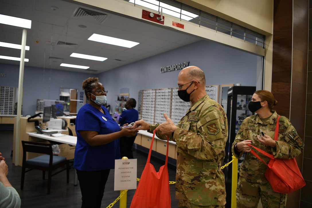 Chief Master Sgt. Harold Kruger (middle), 316th Operations Group superintendent, and Col. Anne-Marie Contreras (right), 316th OG commander, pass out Air Force Birthday hand sanitizers at JBA, Md., Sept. 18, 2020. The COVID-19 pandemic is still an active concern for personnel, so Airmen were invited to come out and get free hand sanitizers as a way to celebrate the Air Force Birthday in a safe and healthy way. (U.S. Air Force photo by Airman 1st Class Spencer Slocum)