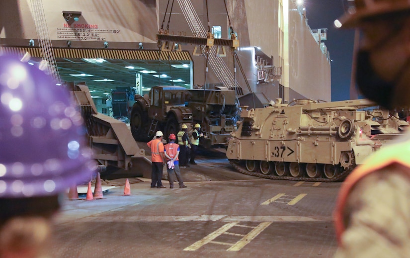 Soldiers and contractors discuss how to move heavy equipment at the Port of Shuiaba, Kuwait, September 11, 2020. The 1184th Deployment and Distribution Support Battalion, from Mobile, AL is responsible for the movement of nearly 400 pieces from several different units on this shipment. (U.S. Army Reserve Photo By Sgt. Vontrae Hampton)