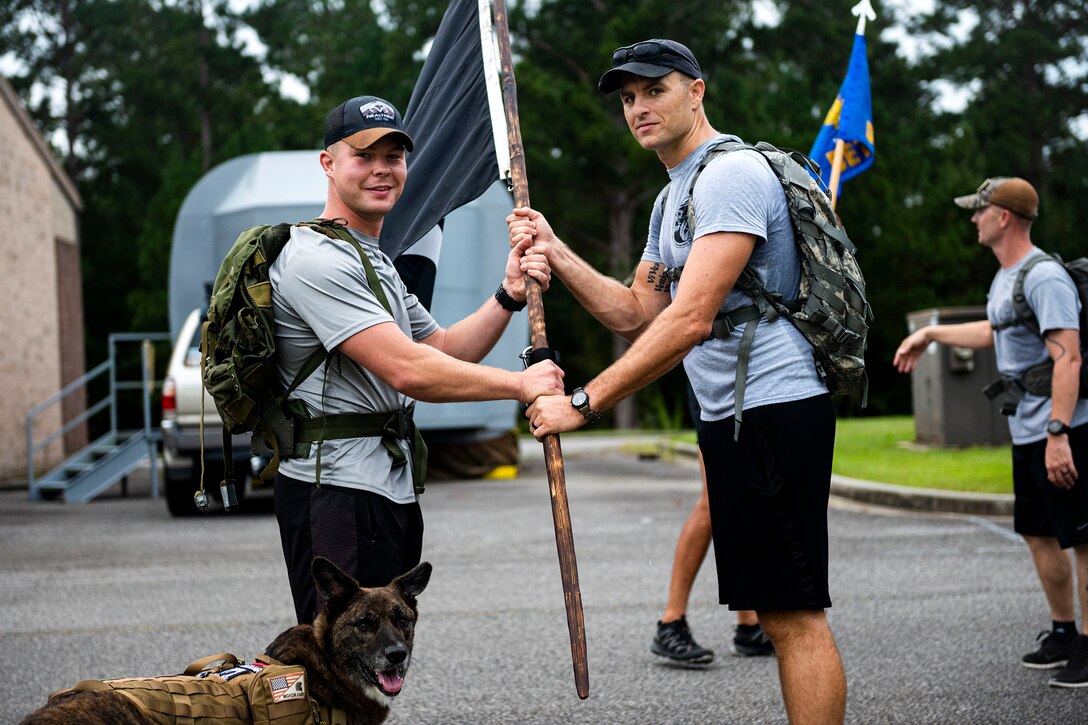 Photo of Airman giving the POW/MIA flag to an Airman.