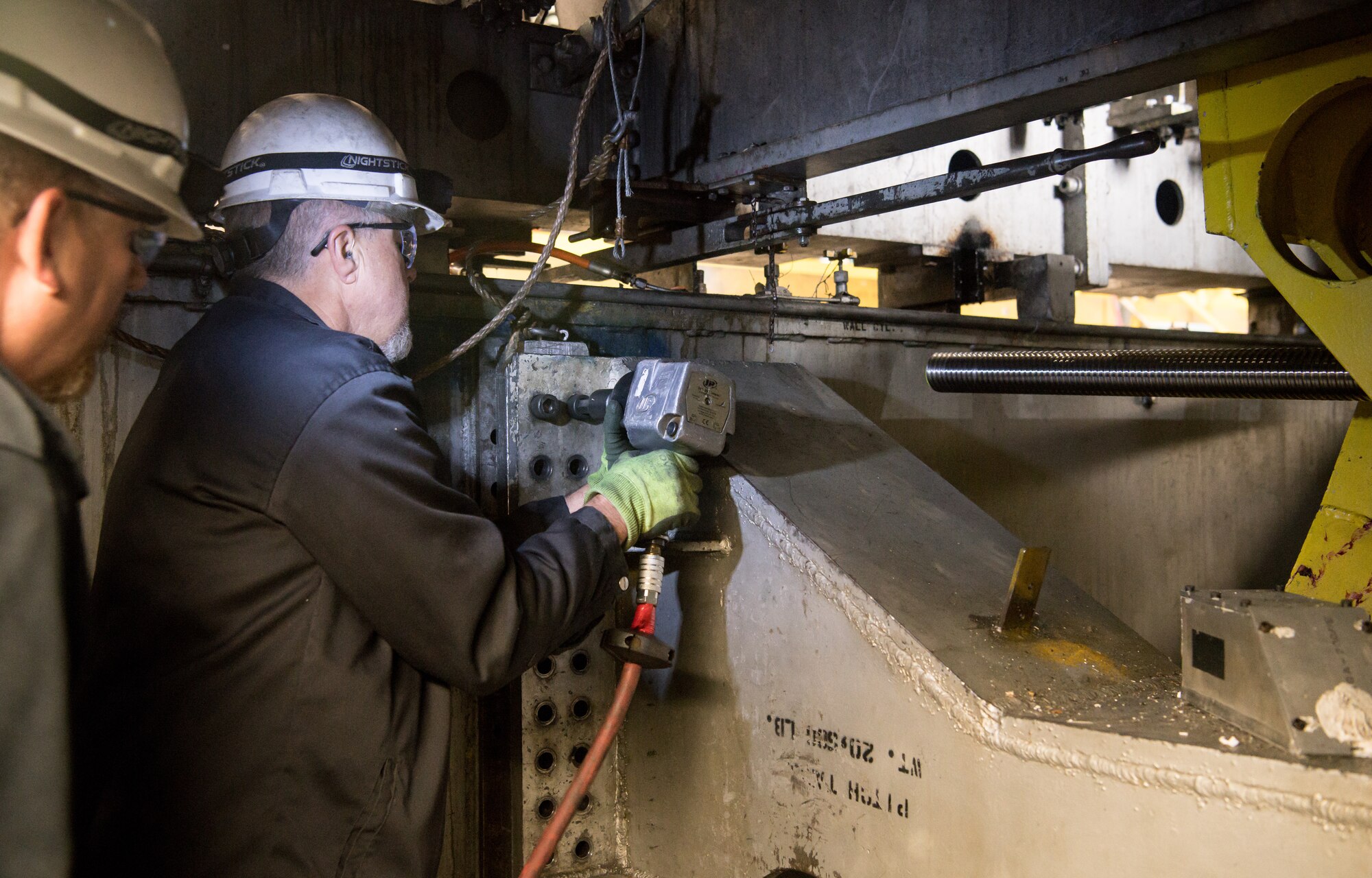 Trey Glenn, an outside machinist, uses an impact wrench to loosen bolts connecting a pitch table to a store separation test cart, March 16, 2020, in the Model Installation Building at Arnold Air Force Base, Tenn. The pitch table is used to adjust the position of the aircraft model within the test section. (U.S. Air Force photo by Jill Pickett)