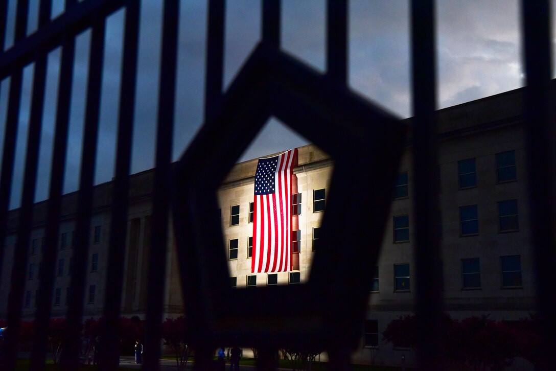 A large American flag is seen through a fence at the Pentagon.