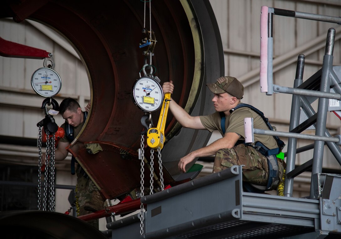 Airman 1st Class Tyler Jackson, 436th Aircraft Maintenance Squadron aerospace propulsion journeyman (right), and Senior Airman Derek Archer, 439th Aircraft Maintenance Squadron aerospace propulsion journeyman (left), utilize winches to lower the engine onto a cradle C-5M Super galaxy engine change September 9, 2020, at Dover Air Force Base, Delaware. Weighing between five to six tons and costing 15.5 million dollars, C-5M Super Galaxy engines are handled with precision and care. (U.S. Air Force photo by Airman 1st Class Jonathan Harding).