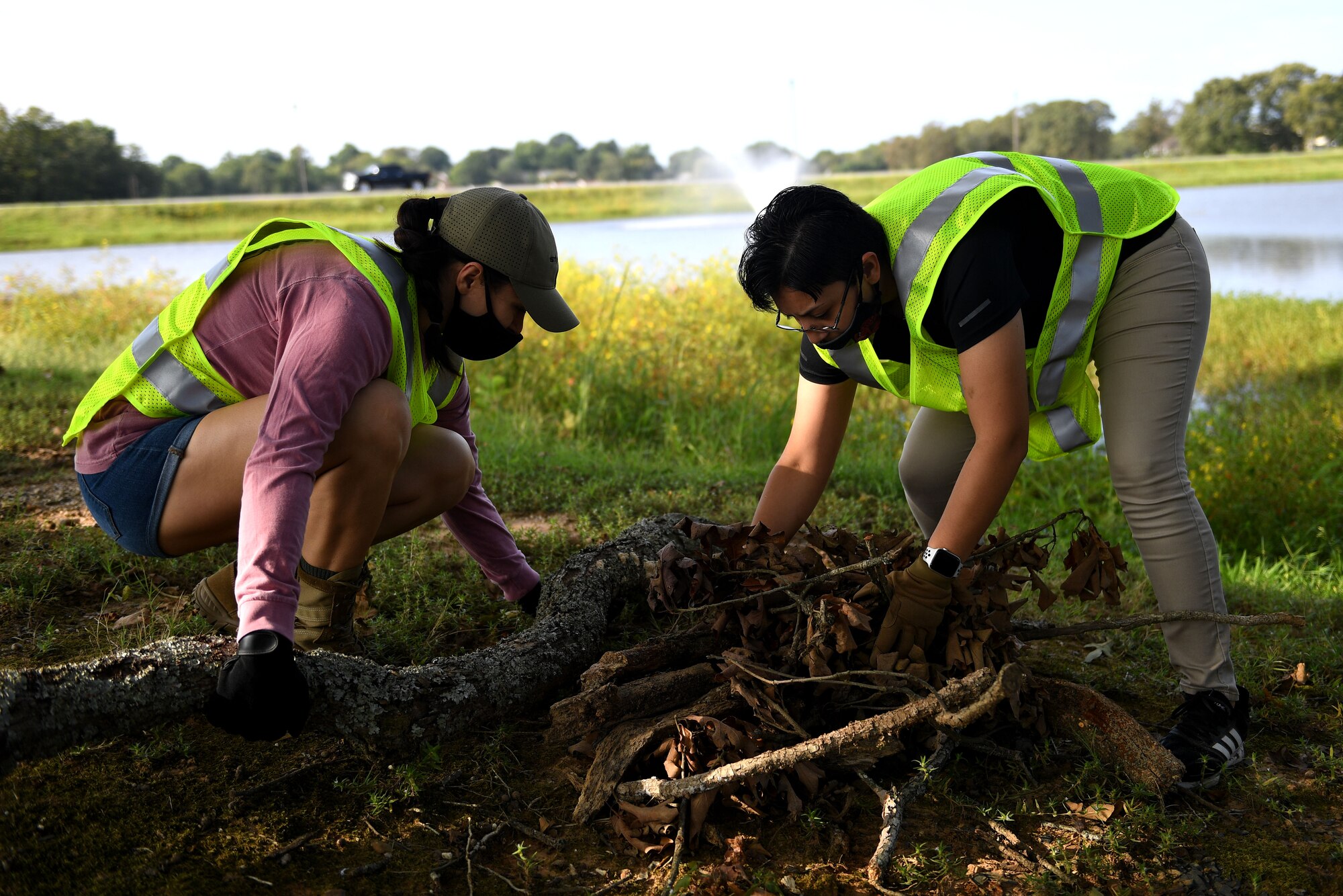 Two people pick up debris