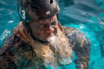 A U.S. Marine aboard Marine Corps Base Hawaii, surfaces out of the water while conducting helicopter underwater egress training, MCBH, July 22, 2020. The purpose of this training is to prepare service members for an emergency exit in case of a crash landing into water. (U.S. Marine Corps photo by Lance Cpl. Jose Angeles)