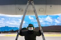 U.S. Marine Corps Cpl. Joshua Cayo, a loadmaster with Marine Aerial Refueler Transport Squadron 152, inspects a KC-130J attached to VMGR-152 prior to a Tilt Air to Air Refueling and Helicopter Air to Air Refueling exercise aboard Marine Corps Air Station, Kaneohe Bay, July 23, 2020. MCAS, Marine Medium Tiltrotor Squadron 363, and Marine Heavy Helicopter Squadron 463 participated in the TAAR and HAAR training to increase readiness, proficiency, and unit cohesion with VMGR-152. (U.S. Marine Corps photo by Lance Cpl. Samantha Sanchez)