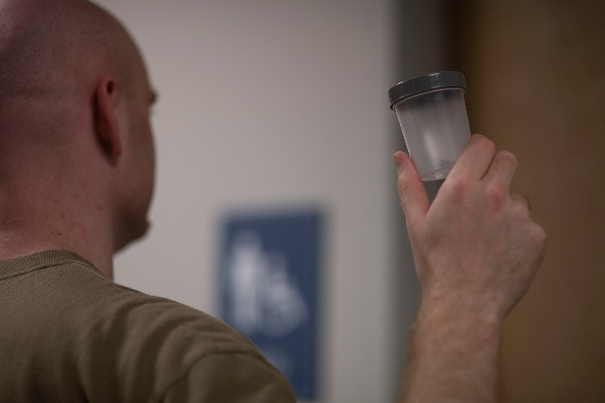 Service member holding up uranalysis sample