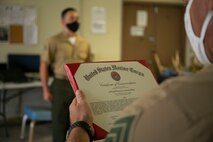 U. S. Marine Corps Lance Cpl. Lance Cpl. Dylan Quinn, additive manufacturing chief, Combat Logistics Battalion 3 stands at attention before receiving a Certificate of accommodation, Sept. 11, 2020. Four CLB-3 Marines were recognized for assisting Tripler Army Medical Center by creating 1,500 face masks using the unit’s 3-D printer. (U.S. Marine Corps photo by Cpl. Jose Angeles)