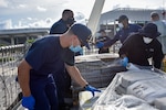 Crew members from Coast Guard Cutter Harriet Lane wrap pallets of drugs for offload at Port Everglades, Florida, Sept. 17, 2020.