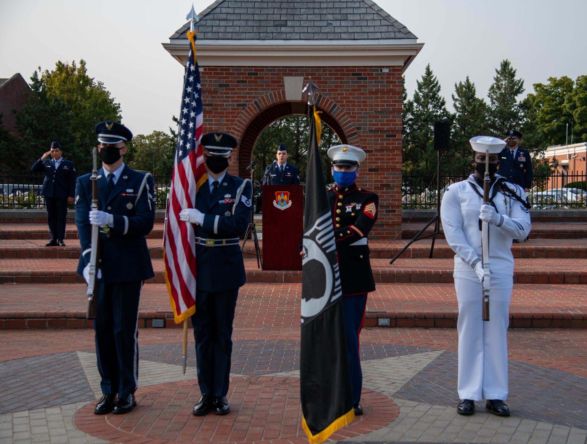 Man sings behind honor guard.