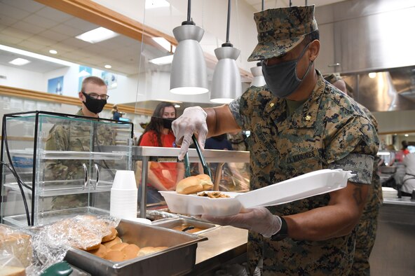 U.S. Marine Corps Maj. Adam Pinkney, Keesler Marine Detachment commanding officer, serves meals to Airmen inside the Azalea Dining Facility at Keesler Air Force Base, Mississippi, Sept. 18, 2020. As part of the Air Force's 73rd Birthday Celebration Week, Sept. 14-18, base leadership served meals to Airmen at the dining facilities. (U.S. Air Force photo by Kemberly Groue)