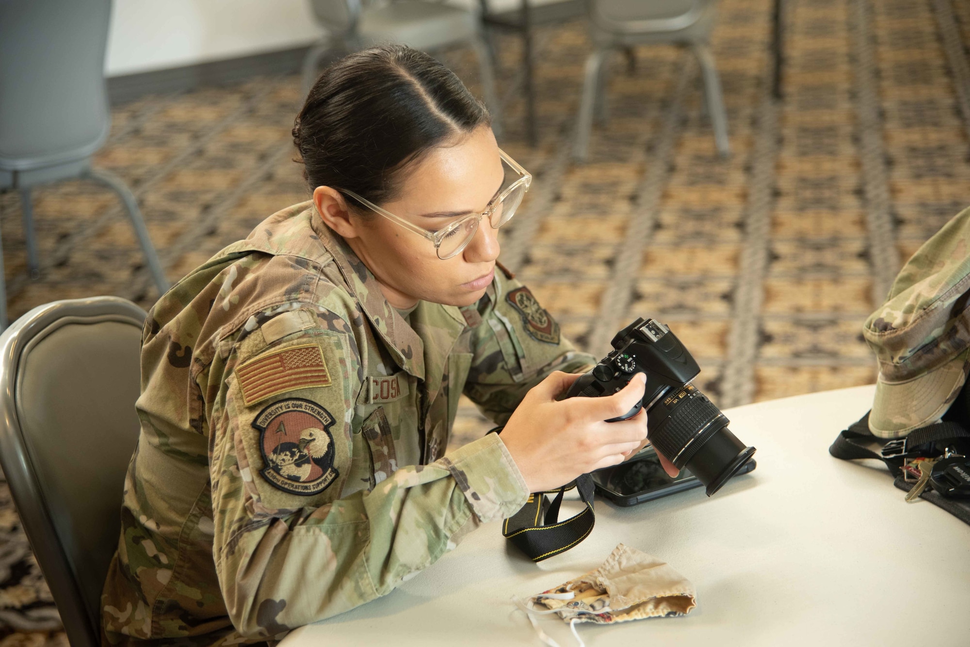 Airman Guinevere Acosta, 436th Operation Support Squadron aircrew flight equipment technician, adjusts her camera’s settings at the professional photography workshop during the Fall Wingman Day Series Sept. 16, 2020, at Dover Air Force Base, Delaware. The photography workshop helped Airmen understand and use basic photography skills. (U.S. Air Force photo by Airman Brandan Hollis)