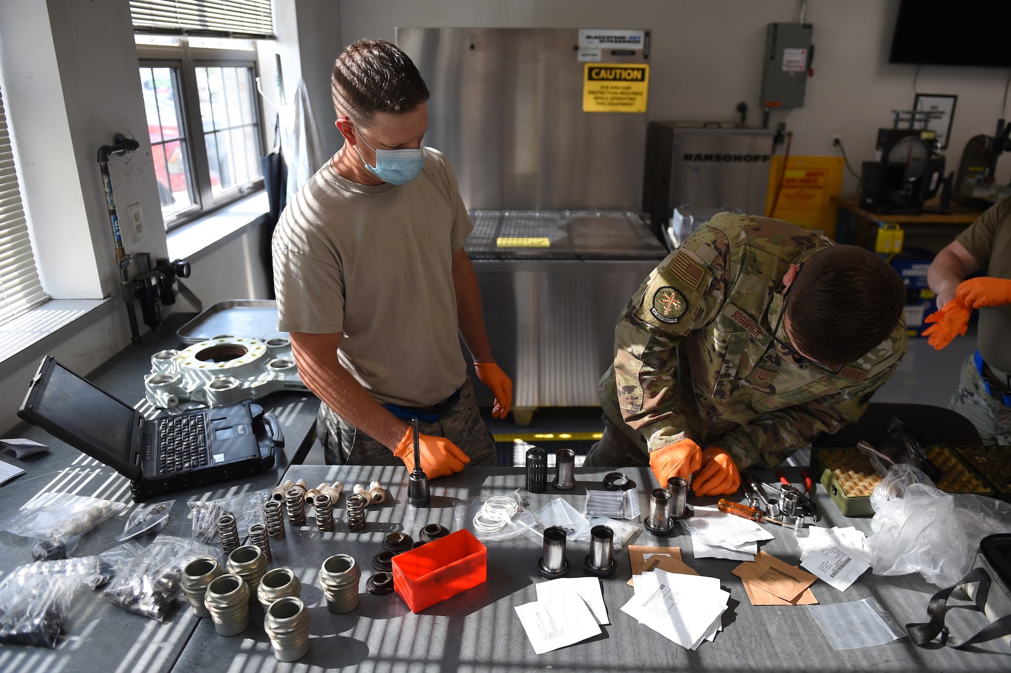 Staff Sgt. Stephan Rozsel and Airman 1st Class Alexander Bogovich, 62nd Maintenance Squadron aircraft hydraulic systems specialists, work on preparing pistons to go into a hydraulic brake system of a C-17 Globemaster III on Joint Base Lewis-McChord, Wash., Sept. 10, 2020. The 62nd MXS hydraulics shop conducts the detailed work that goes into hydraulic brake maintenance on a regular basis. (U.S. Air Force photo by Airman 1st Class Mikayla Heineck)