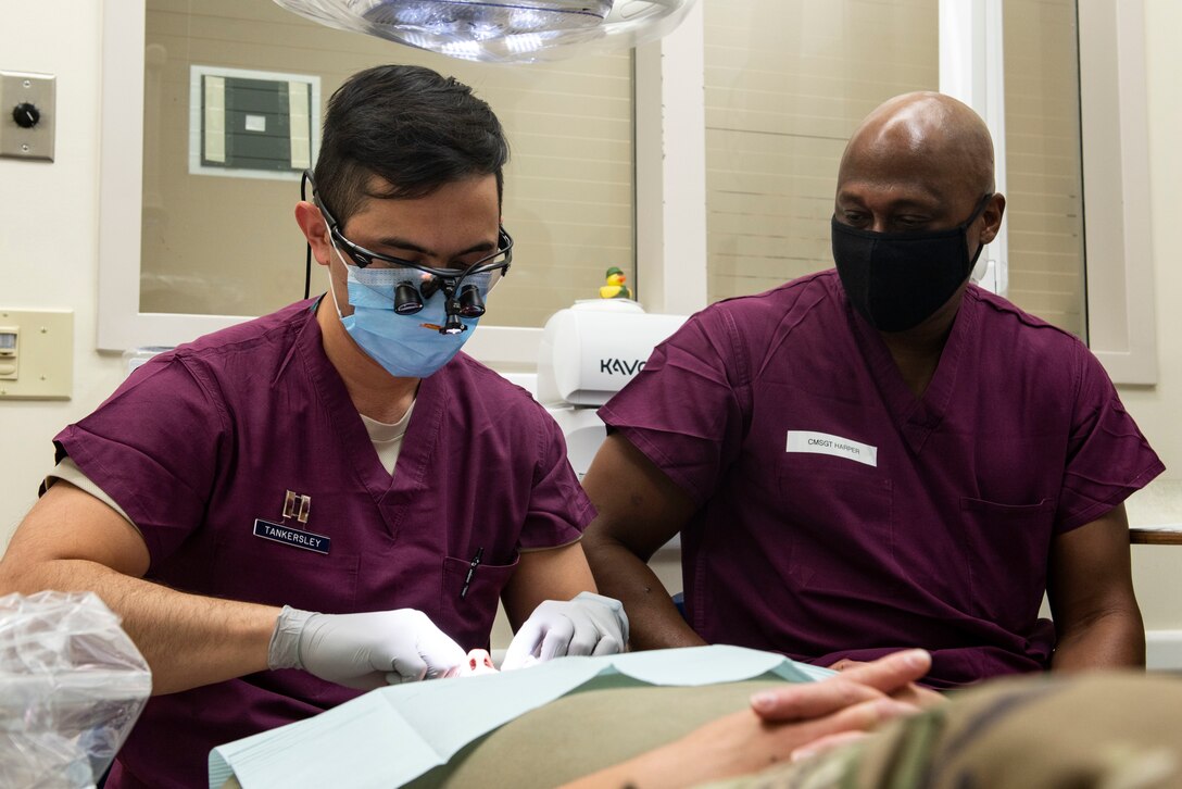 Chief Master Sgt. Ron Harper, 341st Missile Wing command chief, and Capt. Jonathan Tankersley, 341st Operational Medical Readiness Squadron dental hygienist, perform a dental exam on a patient Sept. 16, 2020, at Malmstrom Air Force Base, Mont.
