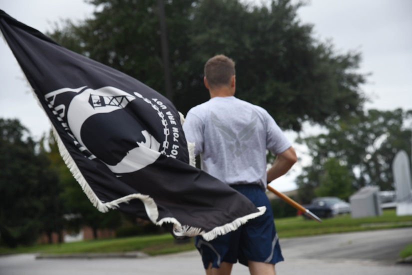 Airman from the 628th Medical group runs with the POW/MIA flag Sept. 18, 2020, at Joint Base Charleston, S.C.