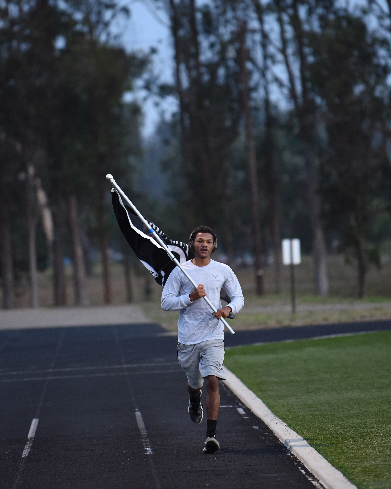 Airman 1st Class Allen Rouse, 30th Civil Engineer Squadron heating, ventilation and air conditioning specialist, runs with the Prisoner of War and Missing in Action flag during the 24- hour POW/MIA remembrance event Sept. 18, 2020, at Vandenberg Air Force Base, Calif. The 24-hour walk or ruck, signifies the countless hours they spent surviving or devising plans to escape. (U.S. Air Force photo by Senior Airman Hanah Abercrombie)