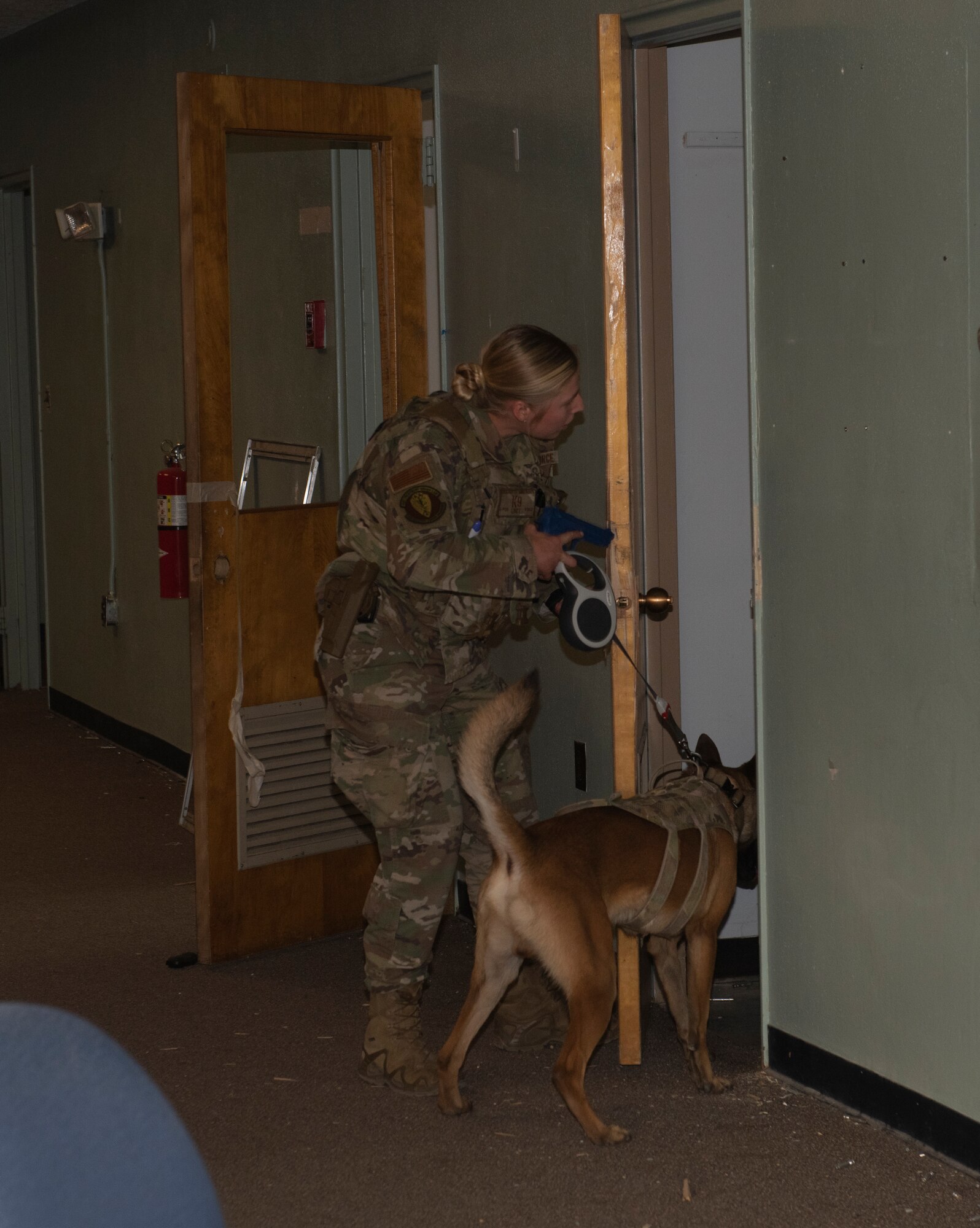 The Airman conducts a secondary sweep with K-9 dog as part of the active shooter exercise.