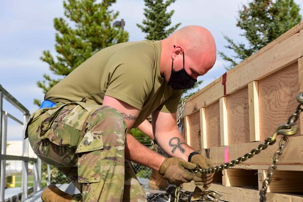U.S. Air Force Staff Sgt. Jordan Ackley, the 354th Logistics Readiness Squadron noncommissioned officer in charge of the cargo deployment function, uses a chain to restrain a crate during Arctic Fox 20-2 on Eielson Air Force Base, Alaska, Sept. 15, 2020. This process restrains the movement of the pieces in all directions with minimal use of equipment or cargo straps. (U.S. Air Force photo by Airman 1st Class Jose Miguel T. Tamondong)