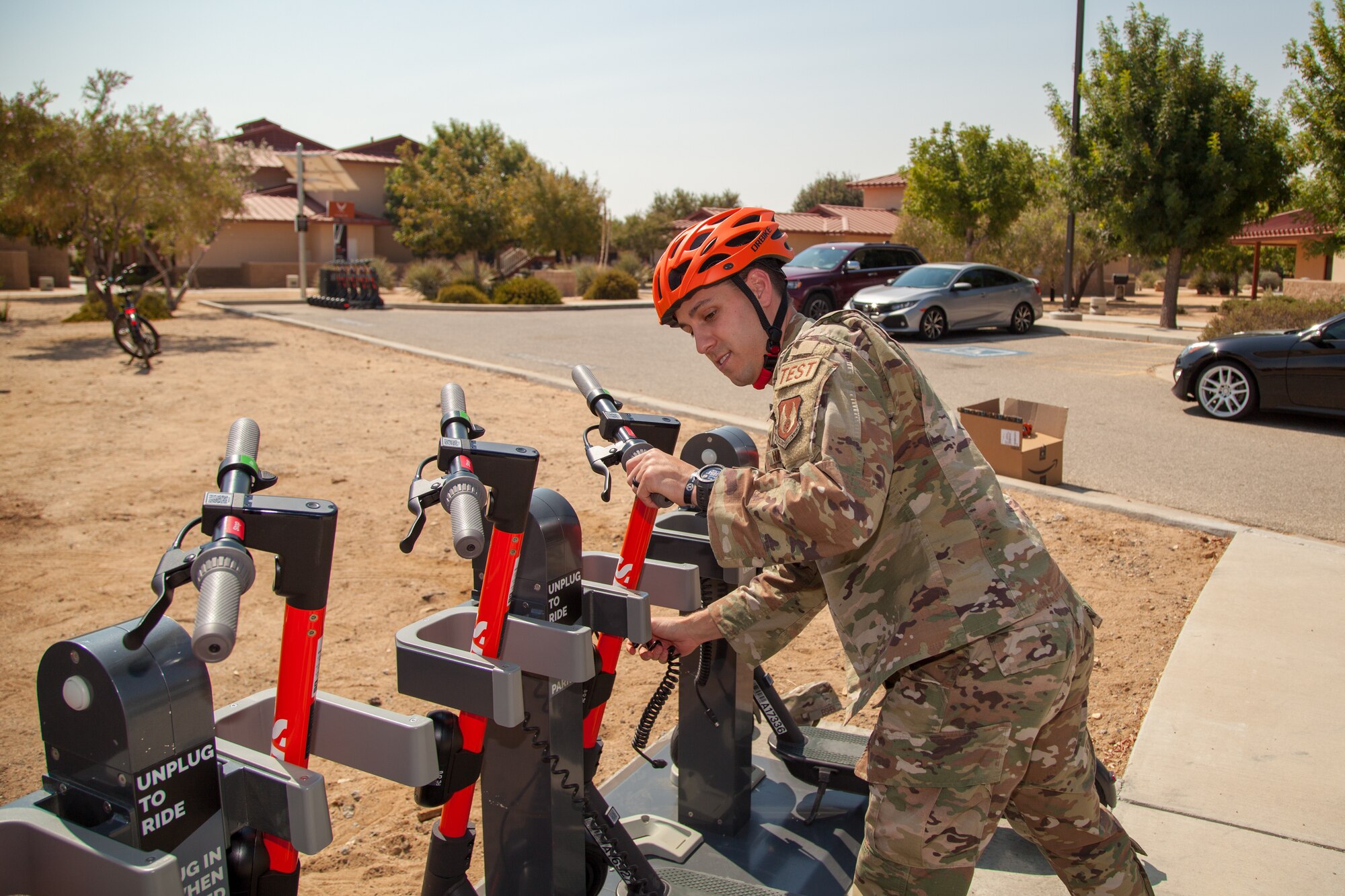Master Sgt. Chad Hardesy, 412th Security Forces Squadron, demonstrates the new Spin scooters near the Airmen dormitories at Edwards Air Force Base, California, during the projects launch Sept. 2. (Air Force photo by Ethan Wagner)