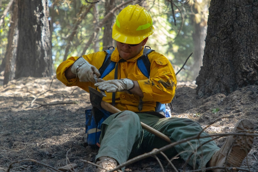 Spc. Bailey Walker with the 14th Brigade Engineer Battalion, from Joint Base Lewis-McChord, Washington, sharpens his Pulaski after mopup operations in Mendocino National Forest.