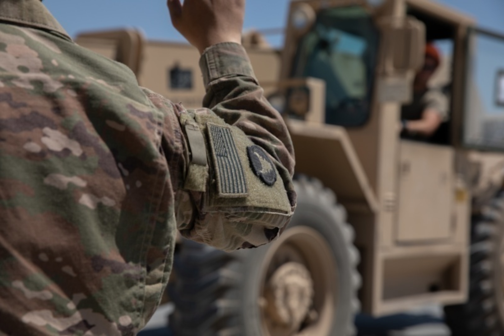 U.S. Army Spc. Tou Vang acts as a guide for U.S. Army Sgt. Kyle Karolus as he moves a conex container at Camp Taji, Iraq July 18, 2020. As members of the Alpha Distro processing center with Alpha Company, 834th Aviation Support Battalion, these Soldiers play a key role in shipping all U.S. owned property before the base transfers from Coalition to Iraqi Security Forces control. (U.S. Army photo by Sgt. Sydney Mariette)