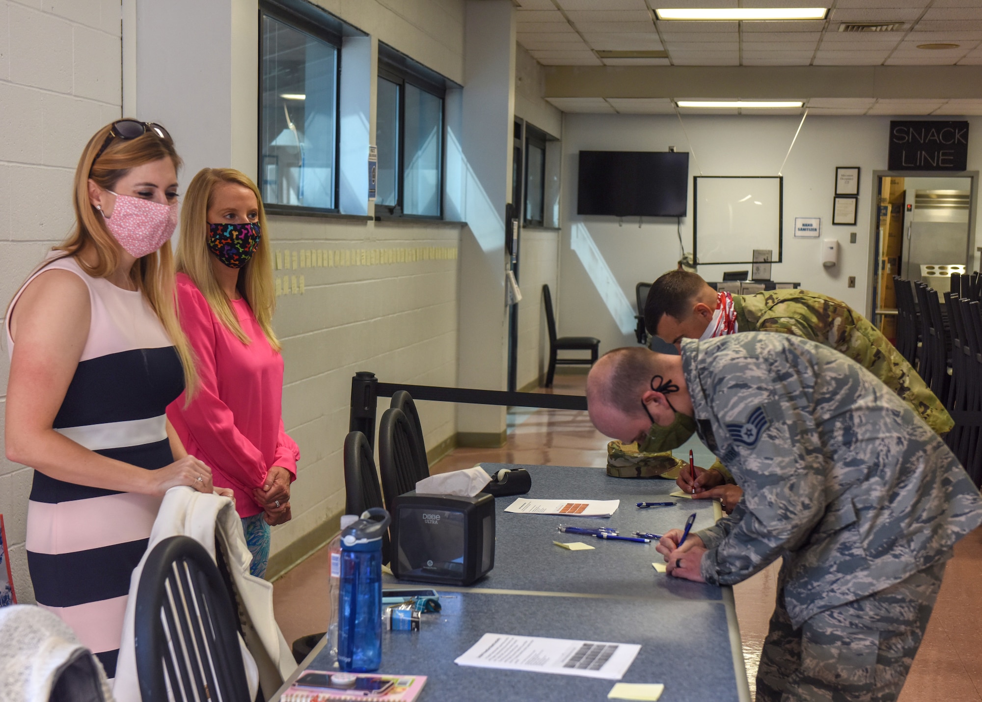Jolene Richardson (left) and A.J. Byerly (right), both directors of psychological health for the 193rd Special Operations Wing, encourage Airmen to write supportive notes during a suicide prevention month activity at the wing dining facility Sept. 19, 2020. The handwritten notes were placed on the wall to demonstrate building a wall of support for fellow Airmen. (Air National Guard photo by Staff Sgt. Rachel Loftis/Released)