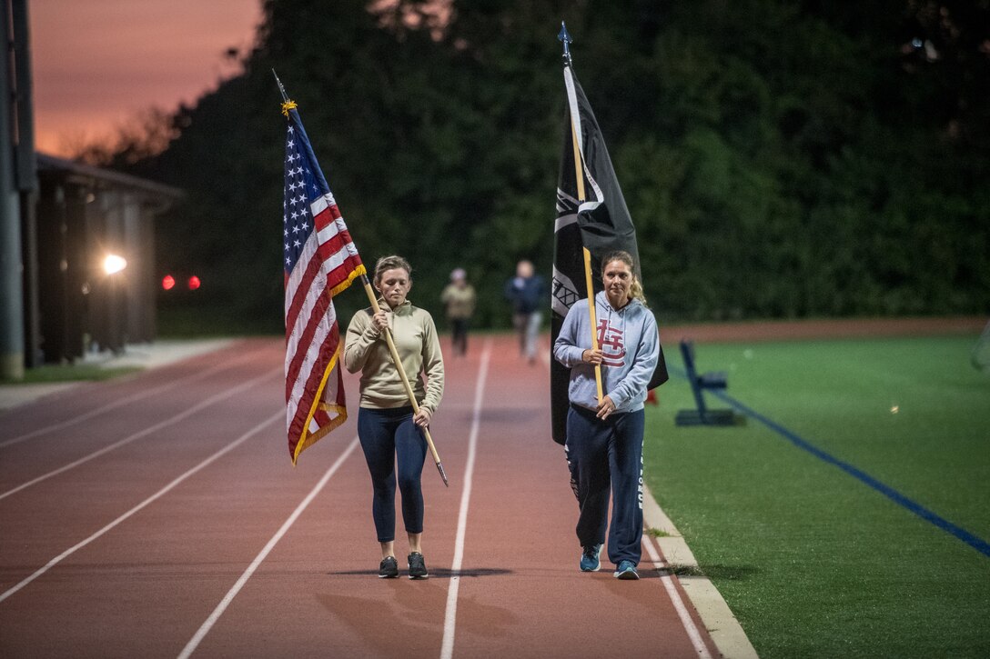Citizen Airmen from the 932nd Airlift Wing honor U.S. military prisoners of war and those missing in action during the 11th Annual POW/MIA Vigil Run at the James Gym track, Scott Air Force Base, Illinois,  September 19, 2020.  The run was hosted by the Air Force Sergeants Association with the USO on site offering hot beverages and food.  This year's event had the extra COVID-19 precautions with maintaining smaller groups safely spaced while moving the flags around the track. (U.S. Air Force photo by Master Sgt. Christopher Parr)