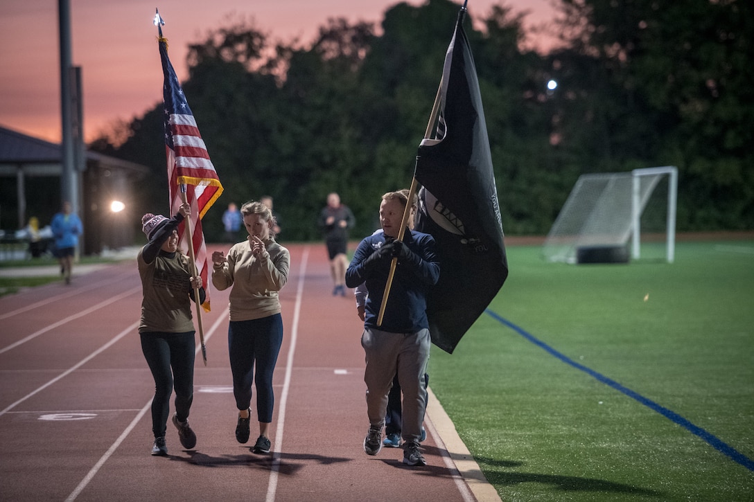 Citizen Airmen from the 932nd Airlift Wing honor U.S. military prisoners of war and those missing in action during the 11th Annual POW/MIA Vigil Run at the James Gym track, Scott Air Force Base, Illinois,  September 19, 2020.  The run was hosted by the Air Force Sergeants Association with the USO on site offering hot beverages and food.  This year's event had the extra COVID-19 precautions with maintaining smaller groups safely spaced while moving the flags around the track. (U.S. Air Force photo by Master Sgt. Christopher Parr)