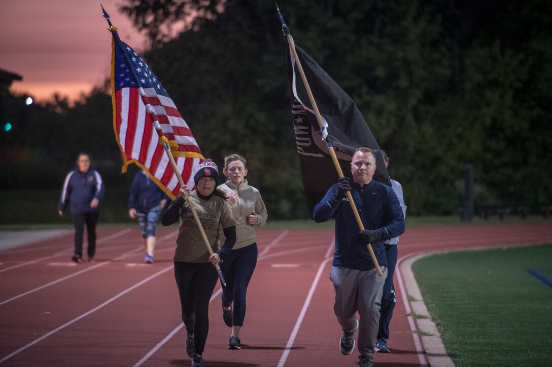 Citizen Airmen from the 932nd Airlift Wing honor U.S. military prisoners of war and those missing in action during the 11th Annual POW/MIA Vigil Run at the James Gym track, Scott Air Force Base, Illinois,  September 19, 2020.  The run was hosted by the Air Force Sergeants Association with the USO on site offering hot beverages and food.  This year's event had the extra COVID-19 precautions with maintaining smaller groups safely spaced while moving the flags around the track. (U.S. Air Force photo by Master Sgt. Christopher Parr)