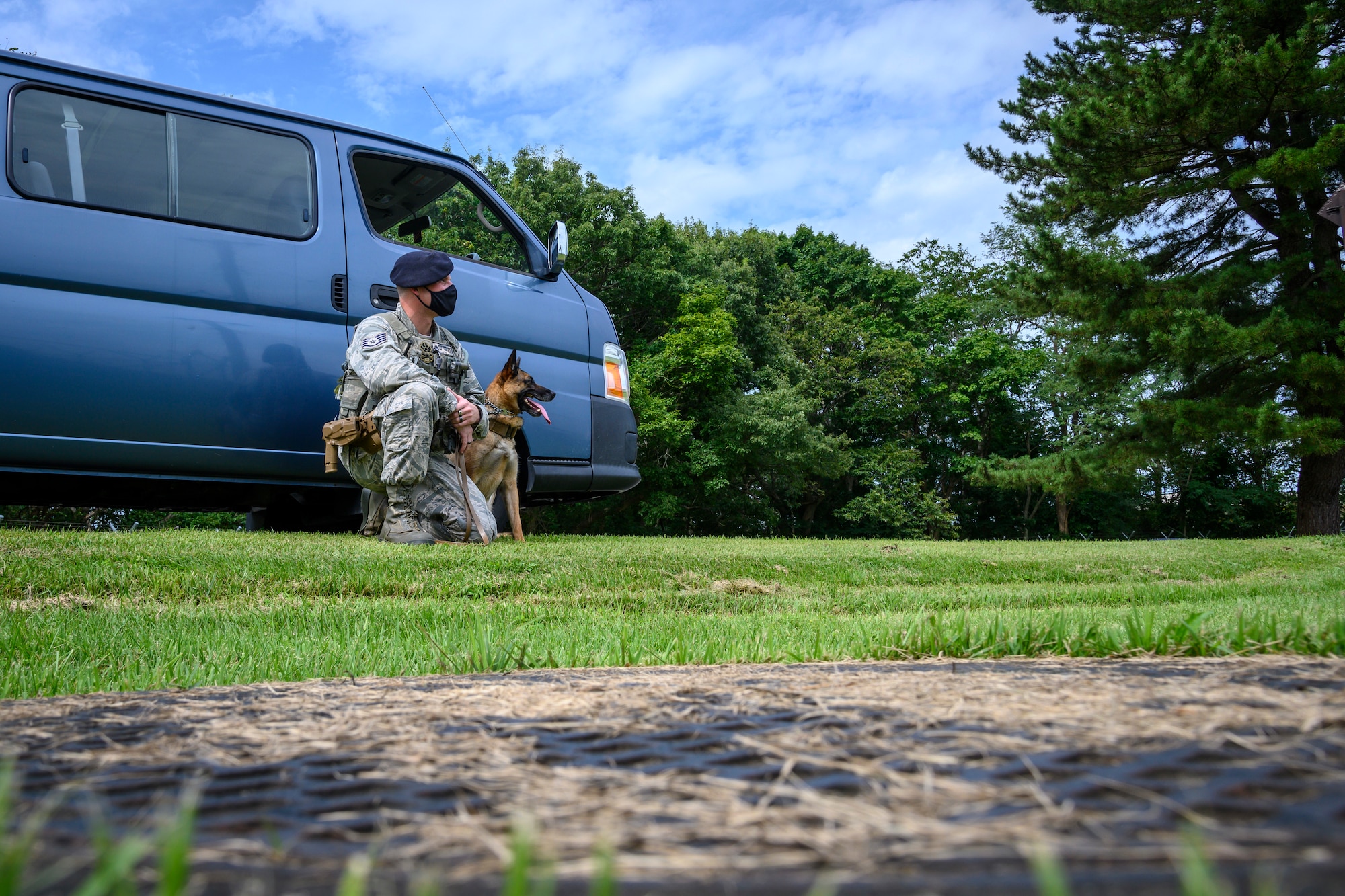 U.S. Air Force Staff Sgt. Anthony Rescheka, a 35th Security Forces Squadron military working dog handler, sits with his MWD, Bella, before a demonstration at Misawa Air Base, Japan, Sept. 17, 2020. Working dog handlers with the 35th Security Forces Squadron's K-9 unit display the skills of their dogs during a demonstration for Chief Master Sgt. Rick Winegardner Jr, the U.S. Forces Japan command chief. The dogs train on how to detect explosives and narcotics as well as perform controlled aggression tactics when detaining suspects. (U.S. Air Force photo by Airman 1st Class China M. Shock)