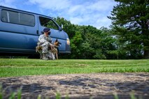 U.S. Air Force Staff Sgt. Anthony Rescheka, a 35th Security Forces Squadron military working dog handler, sits with his MWD, Bella, before a demonstration at Misawa Air Base, Japan, Sept. 17, 2020. Working dog handlers with the 35th Security Forces Squadron's K-9 unit display the skills of their dogs during a demonstration for Chief Master Sgt. Rick Winegardner Jr, the U.S. Forces Japan command chief. The dogs train on how to detect explosives and narcotics as well as perform controlled aggression tactics when detaining suspects. (U.S. Air Force photo by Airman 1st Class China M. Shock)