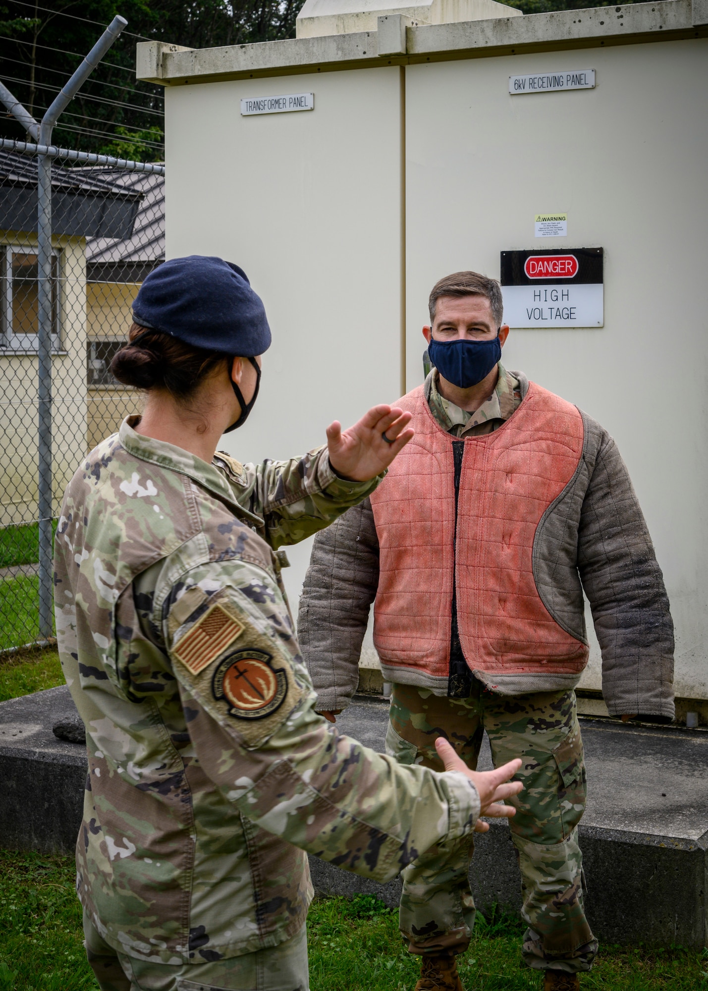 U.S. Air Force Staff Sgt. Amanda Puryear, a 35th Security Forces Squadron military working dog handler, instructs Chief Master Sgt. Rick Winegardner Jr., the U.S. Forces Japan command chief, before a demonstration at Misawa Air Base, Japan, Sept. 17, 2020. Working dog handlers with the 35th Security Forces Squadron's K-9 unit display the skills of their dogs during a demonstration for Chief Master Sgt. Rick Winegardner Jr, the U.S. Forces Japan command chief. The dogs train on how to detect explosives and narcotics as well as perform controlled aggression tactics when detaining suspects. (U.S. Air Force photo by Airman 1st Class China M. Shock)