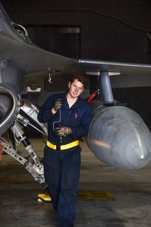 Crew chiefs conduct pre-flight inspections on an F-16 Fighting Falcon