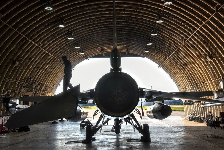 Crew chiefs conduct pre-flight inspections on an F-16 Fighting Falcon