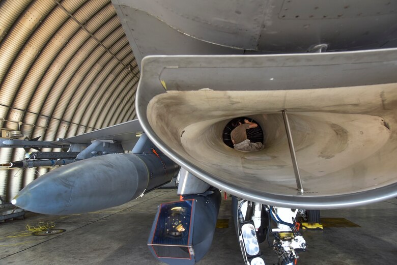 Crew chiefs conduct pre-flight inspections on an F-16 Fighting Falcon