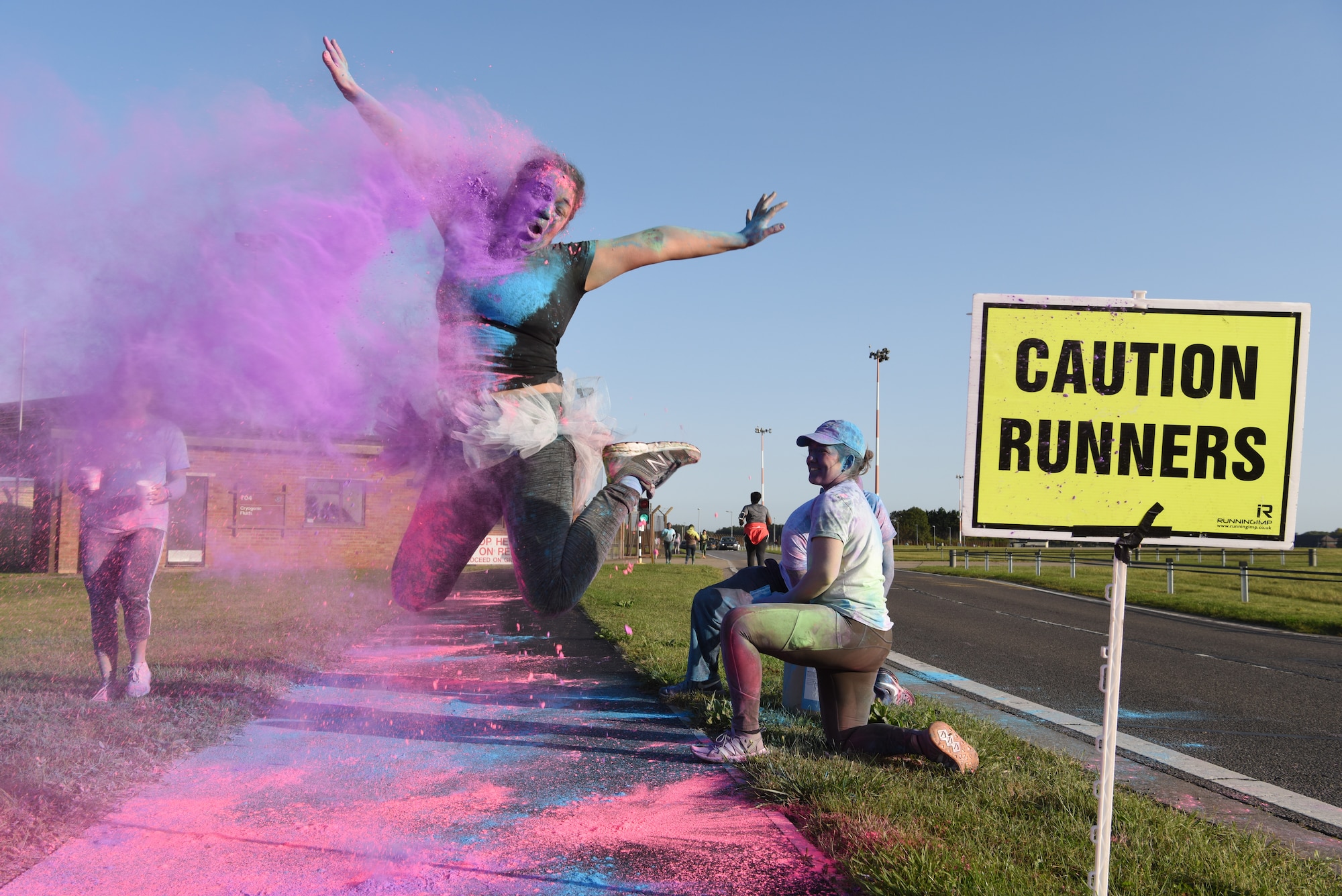Master Sgt. Alejandra Chavez, 100th Air Refueling Wing equal opportunity director, jumps in the air as she is covered with dye at Royal Air Force Mildenhall, England, Sept. 18, 2020.