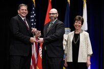 James F. Geurts, Assistant Secretary of the Navy for Research, Development & Acquisition (ASN (RD&A)), joins Dr. Delores M. Etter, former (ASN (RD&A)) and current professor emeritus, Southern Methodist University, as they present the 2017 Dr. Delores M. Etter Top Scientists and Engineers Award for Emergent Engineer Investigators to Dr. Thomas J. Walls, Naval Research Laboratory, during a ceremony at the Pentagon. (U.S. Navy photo by John F. Williams/Released)