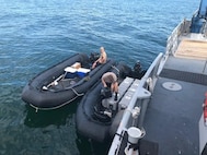 (Left) Aerographer’s Mate 3rd Class Brandon Vanbuytene and Aerographer’s Mate 1st Class Jason Quinn with Naval Oceanography Mine Warfare Center prepare unmanned underwater vehicles for deployment from two combat rubber raiding crafts in the Gulf of Mexico on Aug. 7, 2018, during the Gulf Coast portion of Naval Undersea Warfare Center’s Advanced Naval Technology Exercise. Photo by Kaley Turfitt.